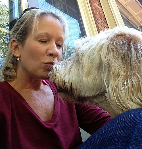 Jenn Meara giving a kiss to a happy client dog